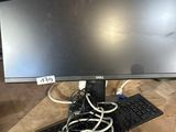 un écran d'ordinateur posé sur un bureau avec un clavier et une souris