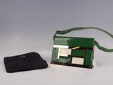 un sac à main vert et un sac à main noir posés sur une table blanche