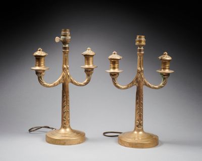 pair of brass candelabs with candles on stands