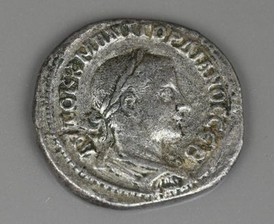 un gros plan d'une pièce d'argent sur laquelle figure l'effigie d'un homme