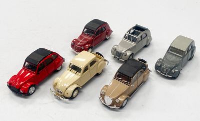 plusieurs petites voitures sont alignées sur une surface blanche