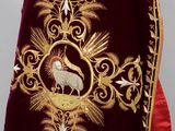 a red and gold coat with a goat on it