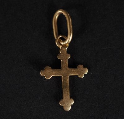 un pendentif en forme de croix en or sur fond noir