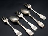 five silver spoons and a fork on a black surface