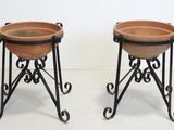 pair of wrought iron plant stands with terracotta pots on stands