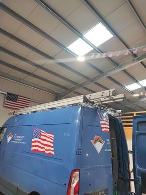 une camionnette bleue avec des drapeaux américains sur les côtés