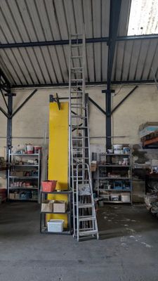 une photo d'un entrepôt avec une échelle au milieu de la pièce