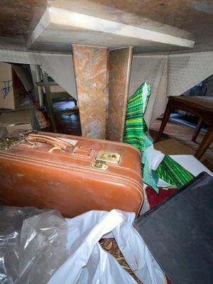 une valise marron posée par terre dans une pièce