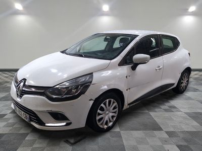une voiture blanche est garée dans une pièce au sol à carreaux