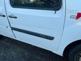 une petite camionnette blanche garée dans un parking