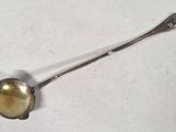 a silver spoon with a spoon handle on a white surface