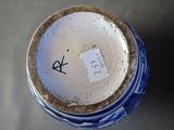a close up of a blue and white vase with a sticker on it