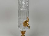 a glass vase with a gold decoration on it