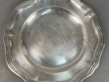 silver plate with scalloped edge on a table top