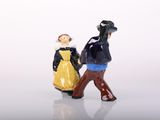 two figurines of a man and a woman holding hands