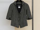 black and white jacket hanging on a clothes rack in a room