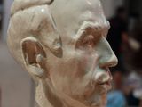 a sculpture of a man ' s head on display in a museum