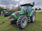 un tracteur vert garé au milieu d'un champ verdoyant