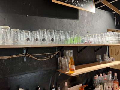 Des bouteilles et des verres sont alignés sur une étagère dans un magasin de spiritueux