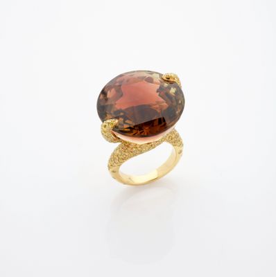 une bague en or surmontée d'une grosse pierre brune