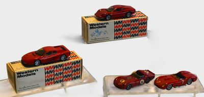 three toy cars sitting on display on a white surface
