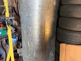 a large metal tank sitting next to a pile of tires