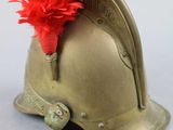 a gold helmet with a red feather on top of it