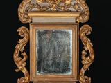 un miroir avec un cadre doré sur fond noir