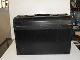 une valise noire posée sur une table blanche