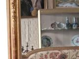 a gold framed mirror on the wall in a living room