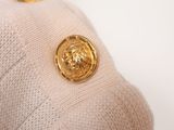 a close up of a sweater with a gold button on it