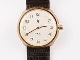 une image d'un gros plan d'une montre-bracelet sur une surface blanche
