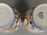 pair of porcelain vases with colorful designs on them sitting on a table