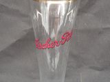 a clear glass vase with a gold rim on a table