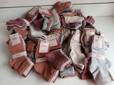 a pile of folded cloths with tags on them