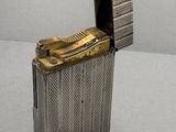 un vieux briquet en argent posé sur une table blanche