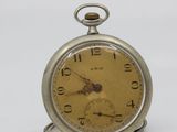 an old pocket watch sitting on top of a white surface