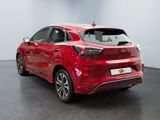 the rear end of a red car parked in a showroom