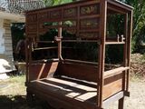 a wooden bed with a hammock on the back of it