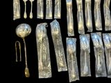 a lot of silver spoons and silverware on a black background