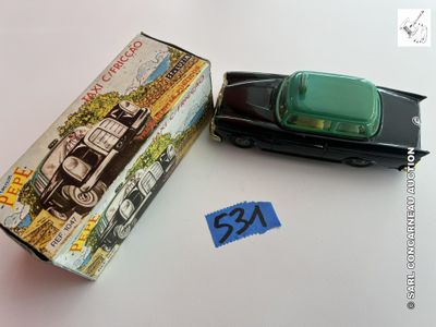 une petite voiture posée à côté d'une boîte sur laquelle est collé un autocollant