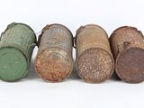 several old metal barrels are lined up on a white surface