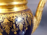 a blue and gold tea pot with a gold handle