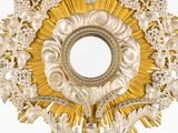 a very ornate gold and silver object with a mirror in it