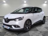 une voiture blanche est garée dans une grande pièce au sol en damier