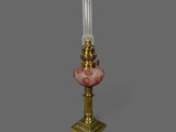 une lampe à l'ancienne surmontée d'un abat-jour en verre