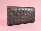 a brown leather wallet on a pink background