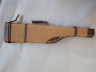 une valise marron posée sur un drap blanc