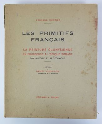 un vieux livre posé sur une table à côté d'un mur blanc