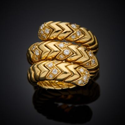 a close up of a gold ring with diamonds on a black surface